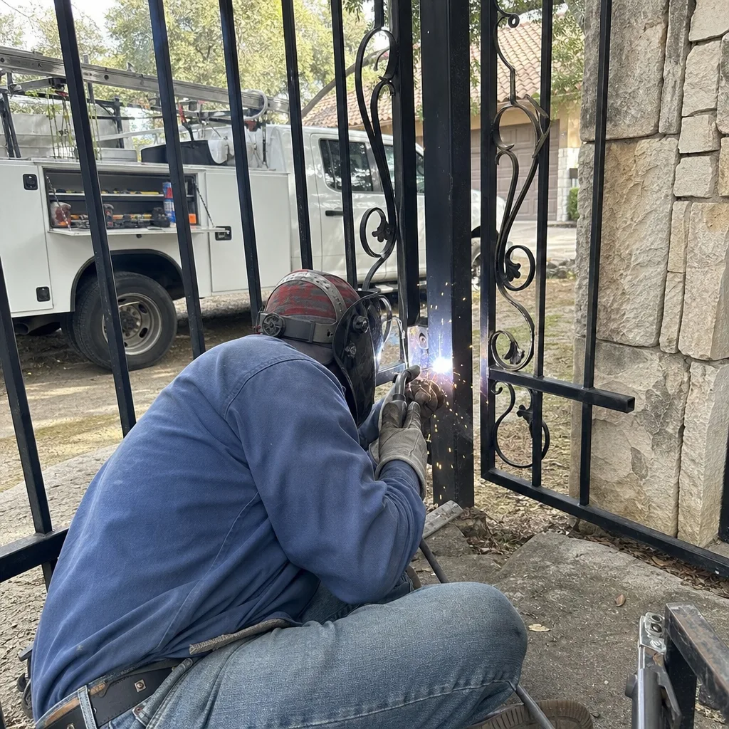 Professional welding technician performing expert metal gate repair and maintenance.